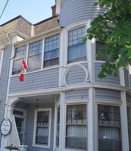 The turret corner of the Duchess of Kent Inn with its oval sign and Canadian flag